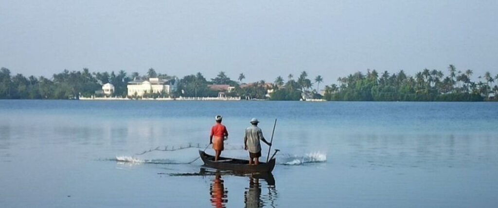 Two Indian fishermen on a canoe in India.