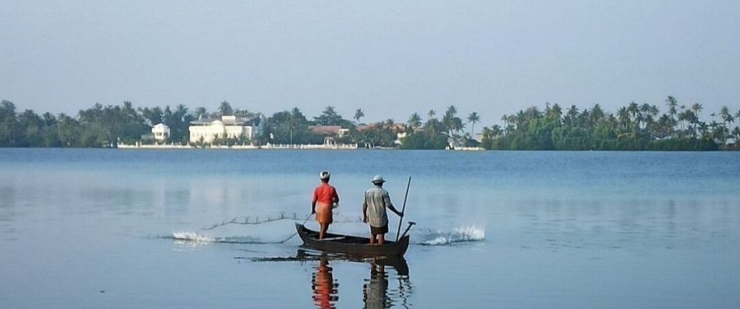 Two Indian fishermen on a canoe in India.