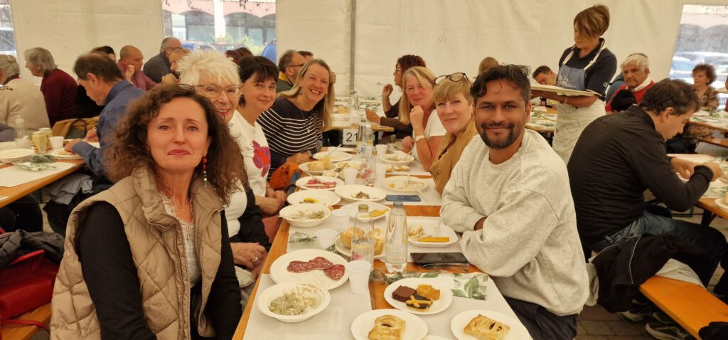 A group of people enjoying a lunch in a marquee.
