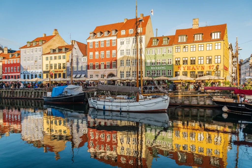 Colourful houses and boats on a riverside street in Copenhagen.