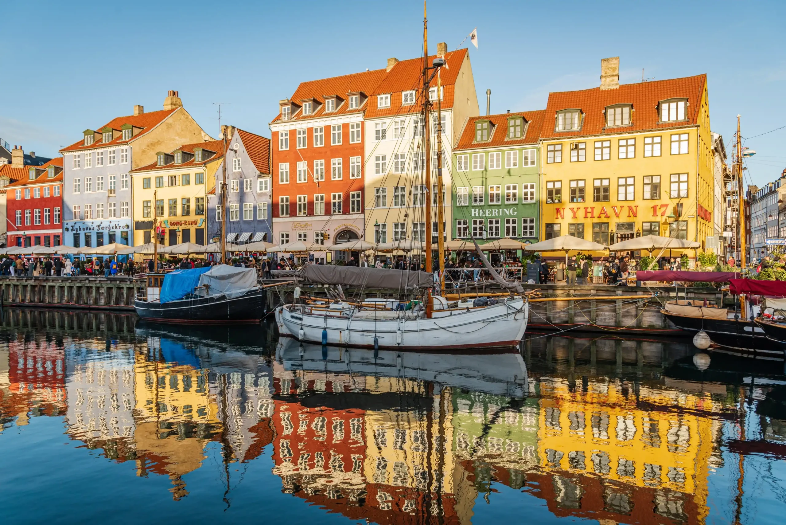 Colourful houses and boats on a riverside street in Copenhagen.